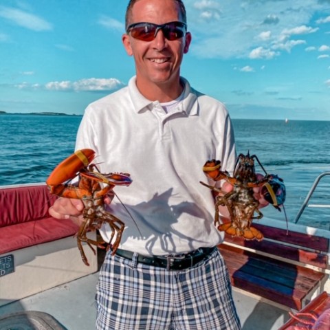 a man holding a hot dog in a body of water